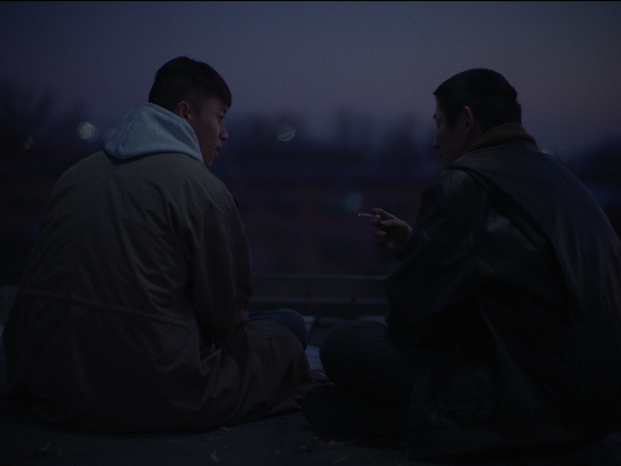 Two figures in a dark exterior