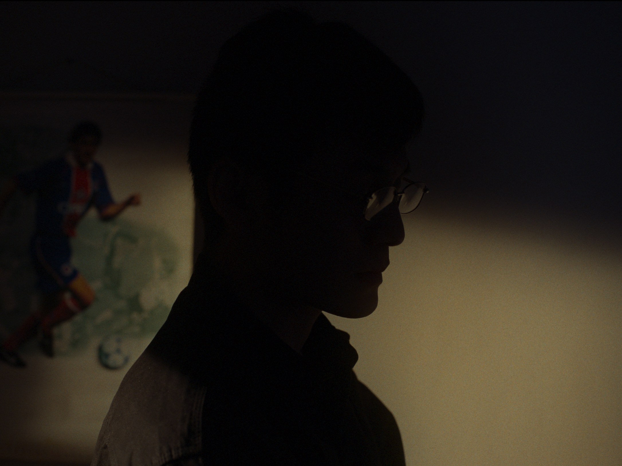 A silhouetted figure in a dim room